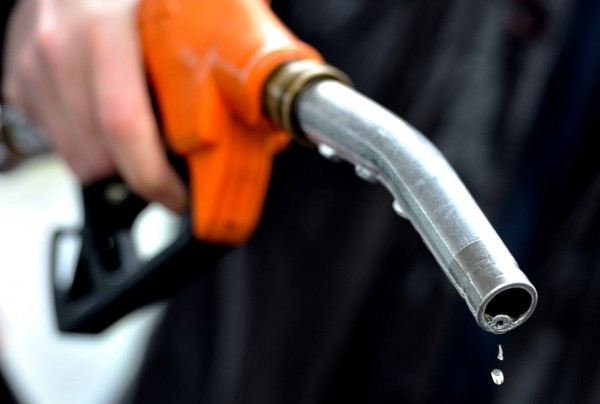 A man finishes to fill up at a gas stati