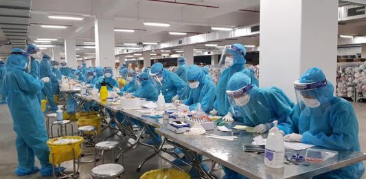 Cán bộ y tế lấy mẫu xét nghiệm tại khu công nghiệp Quang Châu, nơi công ty Hosiden hoạt động
